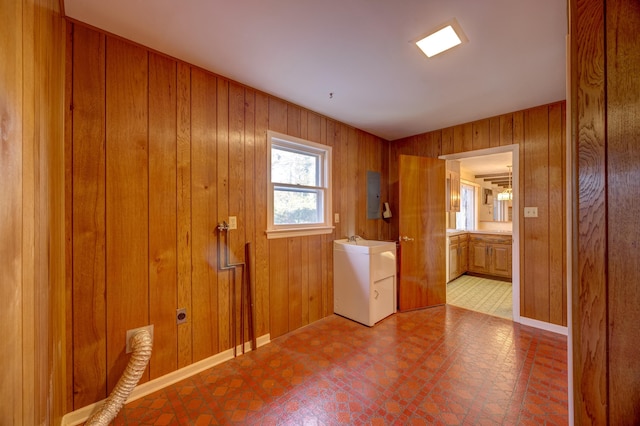 laundry room featuring sink, electric panel, and wood walls