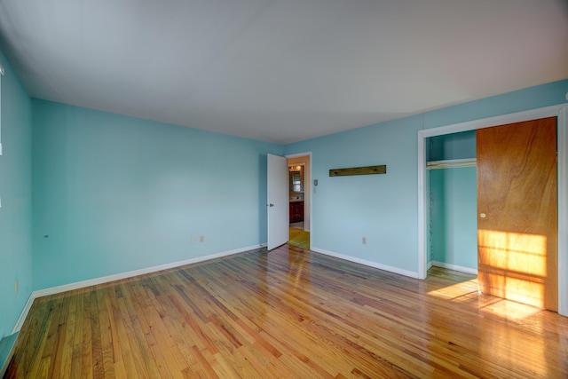 unfurnished bedroom with light hardwood / wood-style flooring and a closet