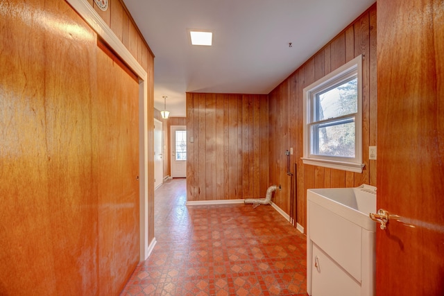 corridor with plenty of natural light and wooden walls