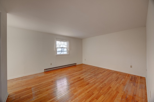 unfurnished room with a baseboard radiator and light hardwood / wood-style flooring