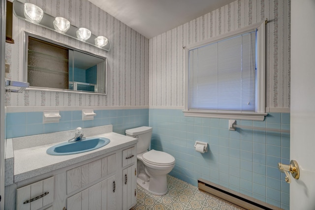 bathroom featuring tile patterned floors, toilet, tile walls, vanity, and a baseboard heating unit