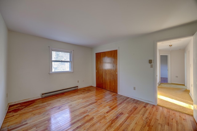 spare room with a baseboard radiator and light hardwood / wood-style flooring