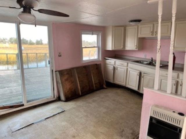 kitchen with heating unit, ceiling fan, and sink