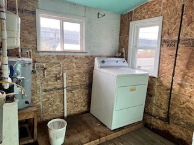 clothes washing area with washer / dryer, dark wood-type flooring, and a healthy amount of sunlight