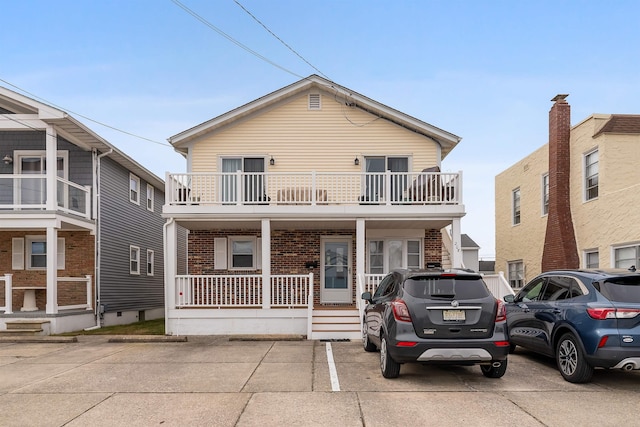 view of front property featuring a balcony and covered porch