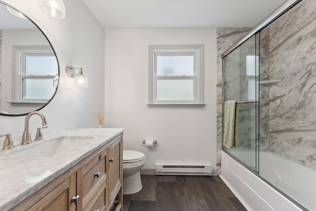 bathroom featuring toilet, baseboard heating, wood finished floors, and a wealth of natural light