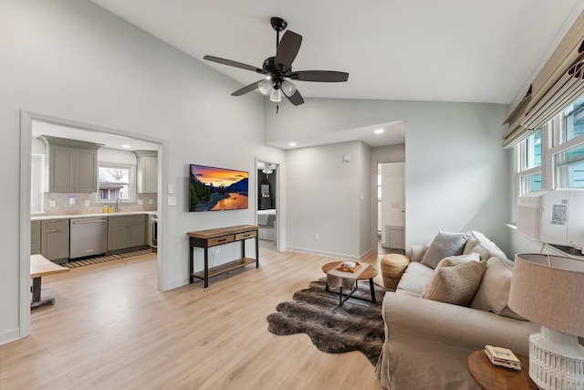 living area with baseboards, a wealth of natural light, and light wood-style floors