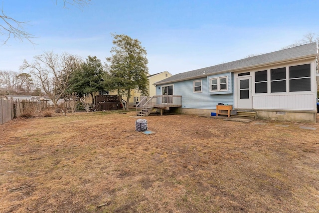 rear view of house with a yard, entry steps, crawl space, fence, and a deck