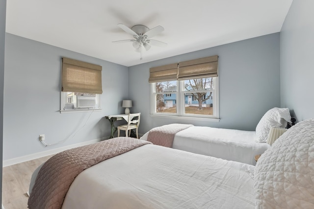 bedroom featuring ceiling fan, wood finished floors, and baseboards