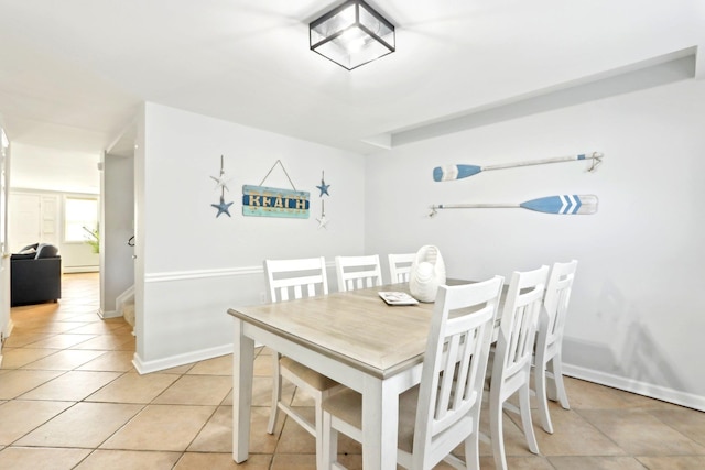 dining room with light tile patterned floors and baseboards