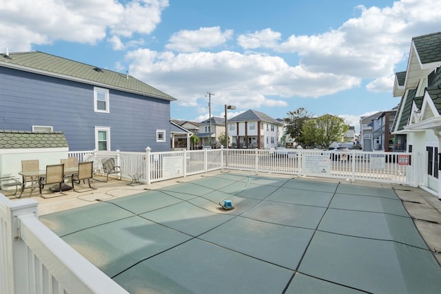 community pool with a residential view, fence, and a patio area