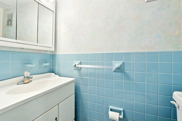 half bath with toilet, visible vents, and vanity