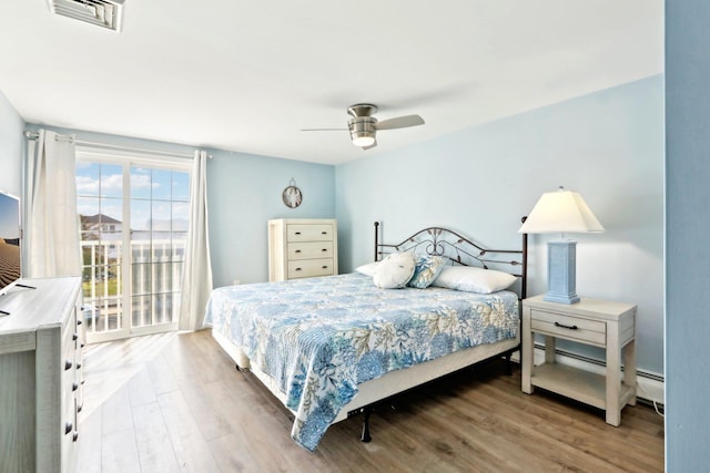 bedroom with visible vents, wood finished floors, and ceiling fan