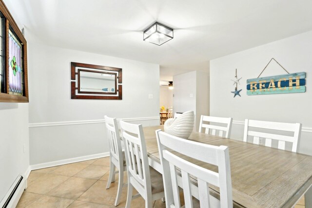 dining space with light tile patterned floors, baseboard heating, and baseboards