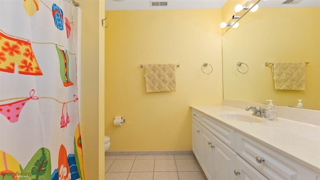 bathroom with tile patterned flooring, vanity, and toilet