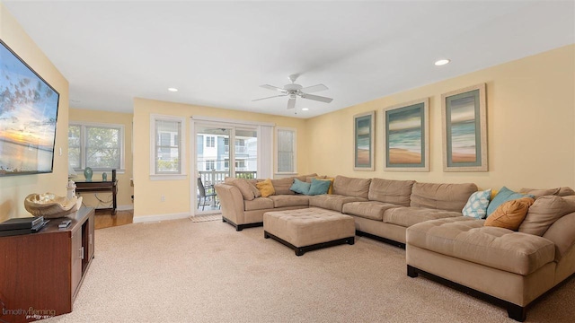 living room with light carpet, ceiling fan, and a healthy amount of sunlight