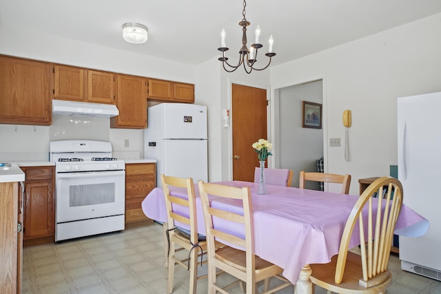 kitchen with a chandelier, white appliances, and hanging light fixtures