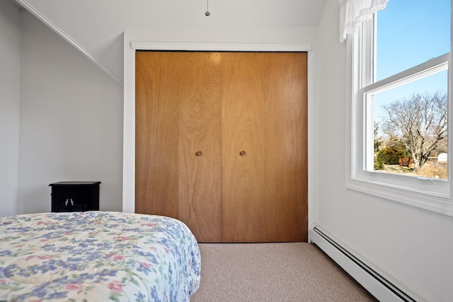 bedroom with baseboard heating, a closet, and carpet floors