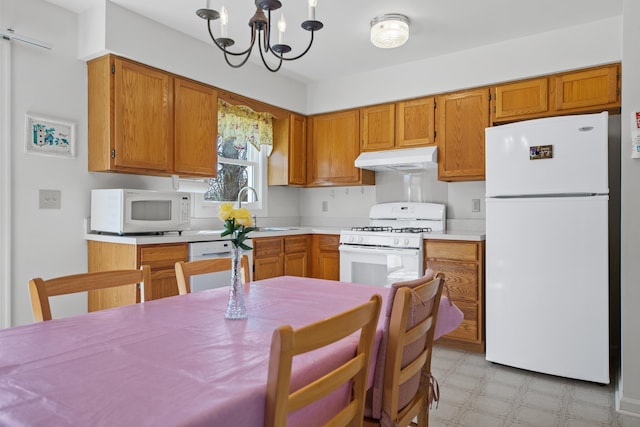 kitchen with a notable chandelier, white appliances, sink, and decorative light fixtures