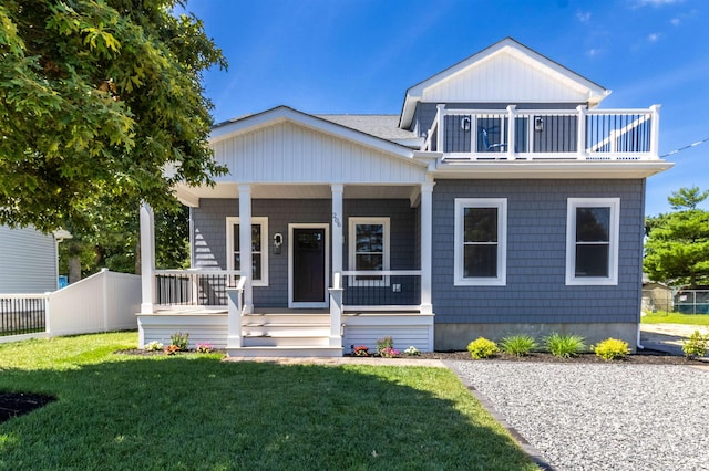 view of front of house with a balcony, covered porch, and a front yard