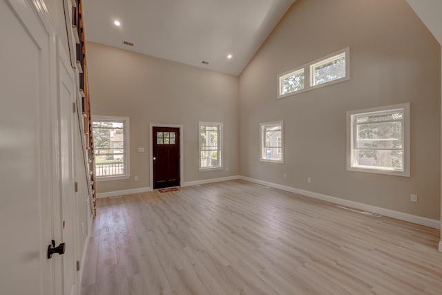 entrance foyer with a high ceiling and light hardwood / wood-style floors