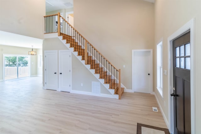 foyer featuring a towering ceiling and light hardwood / wood-style floors