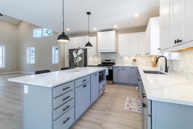 kitchen featuring a center island, white cabinetry, sink, and appliances with stainless steel finishes