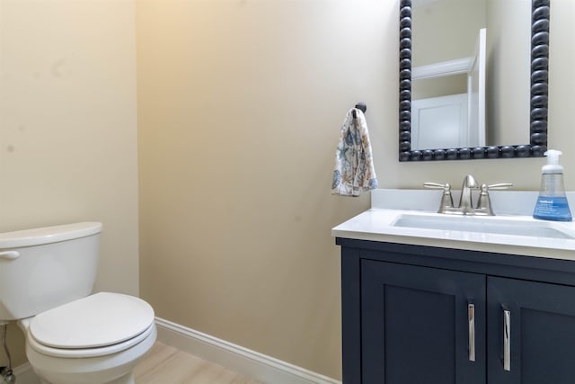 bathroom featuring vanity, wood-type flooring, and toilet