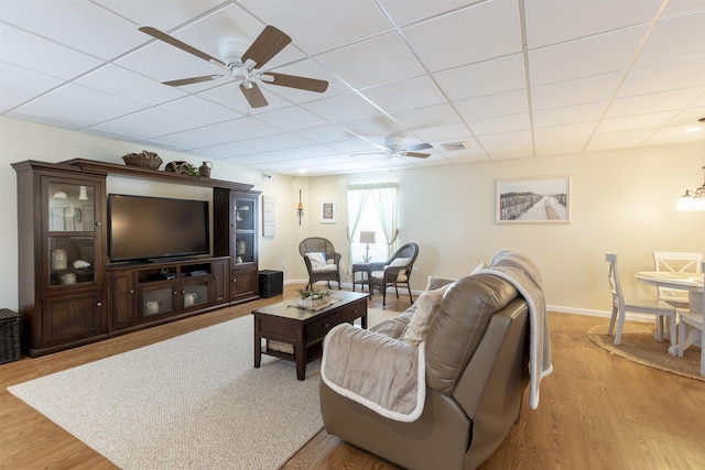 living room with light wood-type flooring, ceiling fan, and a paneled ceiling