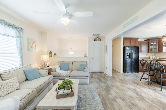 living room with light hardwood / wood-style flooring and ceiling fan