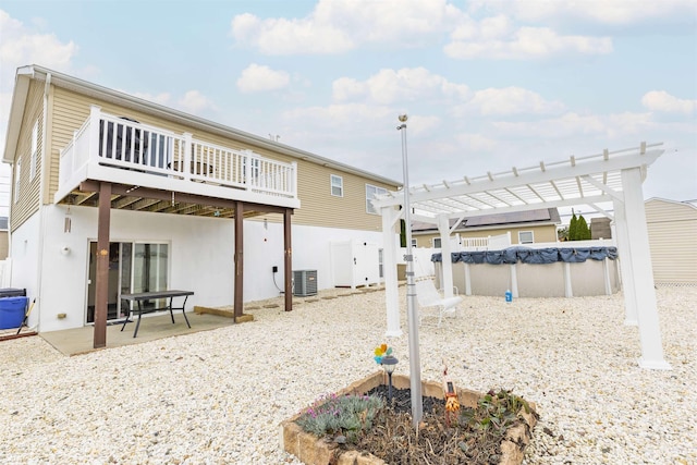 back of property featuring a swimming pool side deck, cooling unit, a patio area, and a pergola