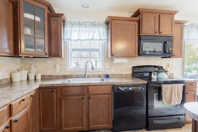 kitchen with decorative backsplash, sink, and black appliances