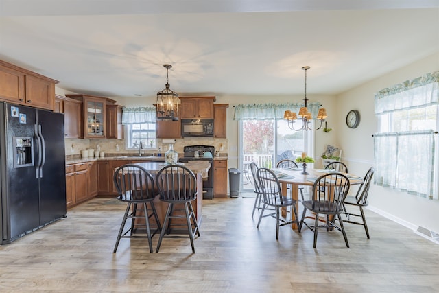 dining space with light hardwood / wood-style floors, a notable chandelier, and sink