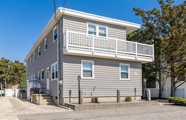 9903 2nd Ave, Stone Harbor, NJ 08247 - view of side of property featuring a balcony, fence, and a gate