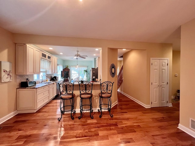 48 Wynndemere Ct, Cape May Court House, NJ 08210 - kitchen featuring stainless steel appliances, a breakfast bar, light wood-style flooring, and baseboards