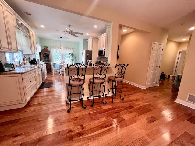 48 Wynndemere Ct, Cape May Court House, NJ 08210 - kitchen featuring stainless steel appliances, a ceiling fan, a breakfast bar area, light wood-style flooring, and a peninsula