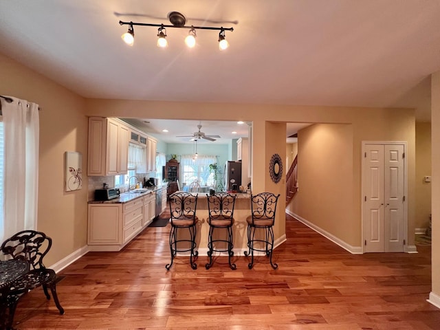 48 Wynndemere Ct, Cape May Court House, NJ 08210 - kitchen with stainless steel appliances, a sink, light wood-style flooring, and a breakfast bar