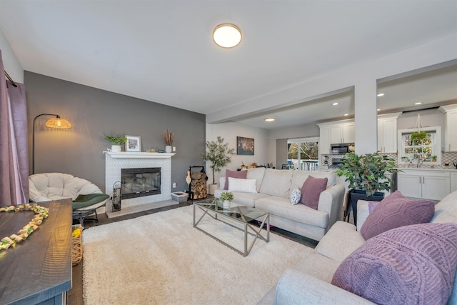 living room with a fireplace with flush hearth and recessed lighting