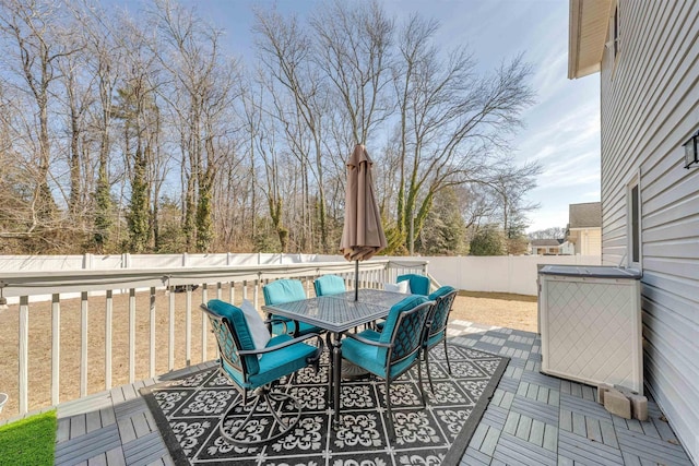 wooden terrace featuring outdoor dining space and a fenced backyard