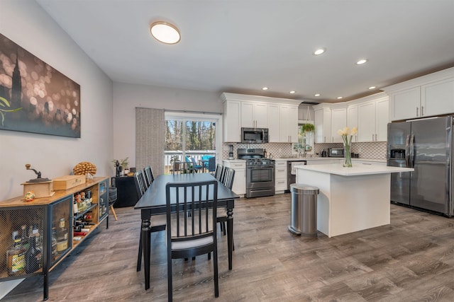 kitchen featuring white cabinetry, appliances with stainless steel finishes, decorative backsplash, and dark wood-type flooring