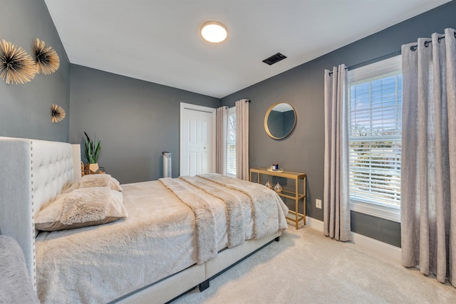 bedroom with carpet floors, baseboards, visible vents, and a closet