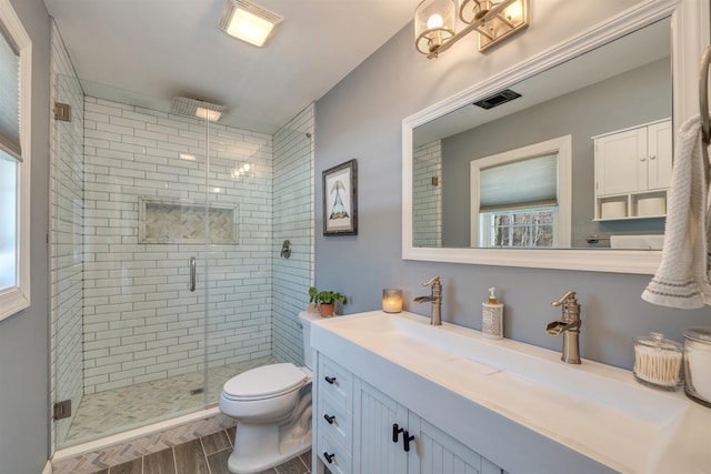 full bathroom featuring visible vents, a stall shower, vanity, and toilet