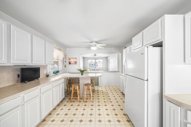 28 89th St, Sea Isle City, NJ 08243 - kitchen with white cabinetry, ceiling fan, light countertops, and freestanding refrigerator
