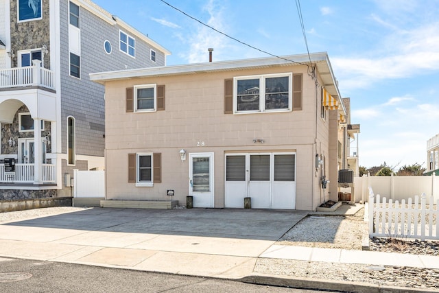 view of front of property with concrete driveway and fence