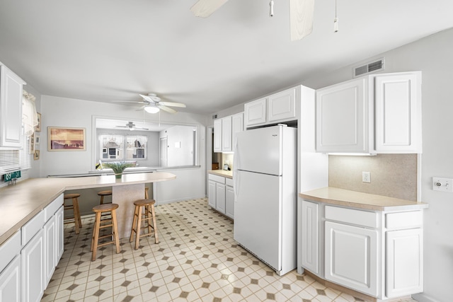 28 89th St, Sea Isle City, NJ 08243 - kitchen with white cabinetry, light floors, visible vents, and freestanding refrigerator