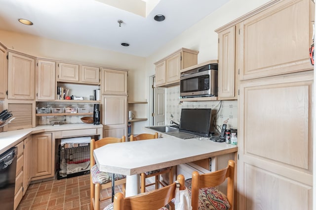 kitchen featuring decorative backsplash, sink, black dishwasher, and light brown cabinetry