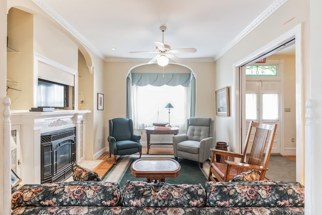 living room with ceiling fan and ornamental molding