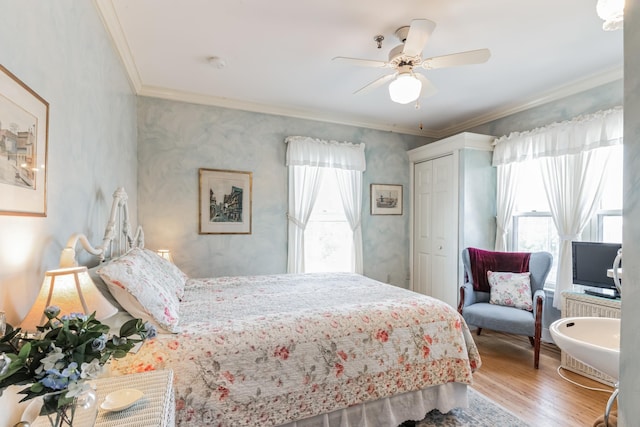 bedroom with multiple windows, ceiling fan, a closet, and light hardwood / wood-style floors