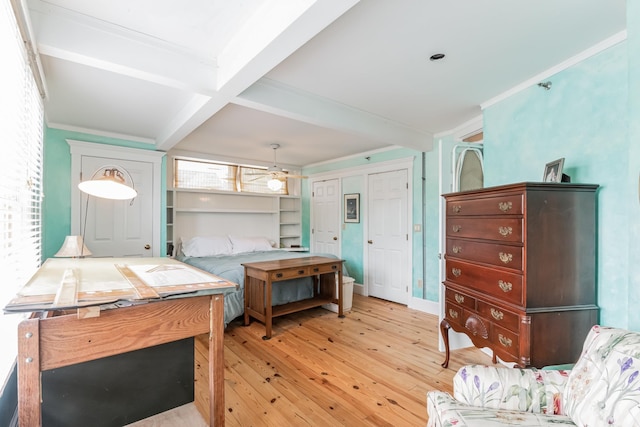 bedroom with beamed ceiling, light hardwood / wood-style floors, and ornamental molding