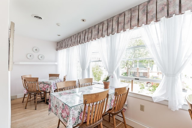 dining room with a healthy amount of sunlight and light hardwood / wood-style floors